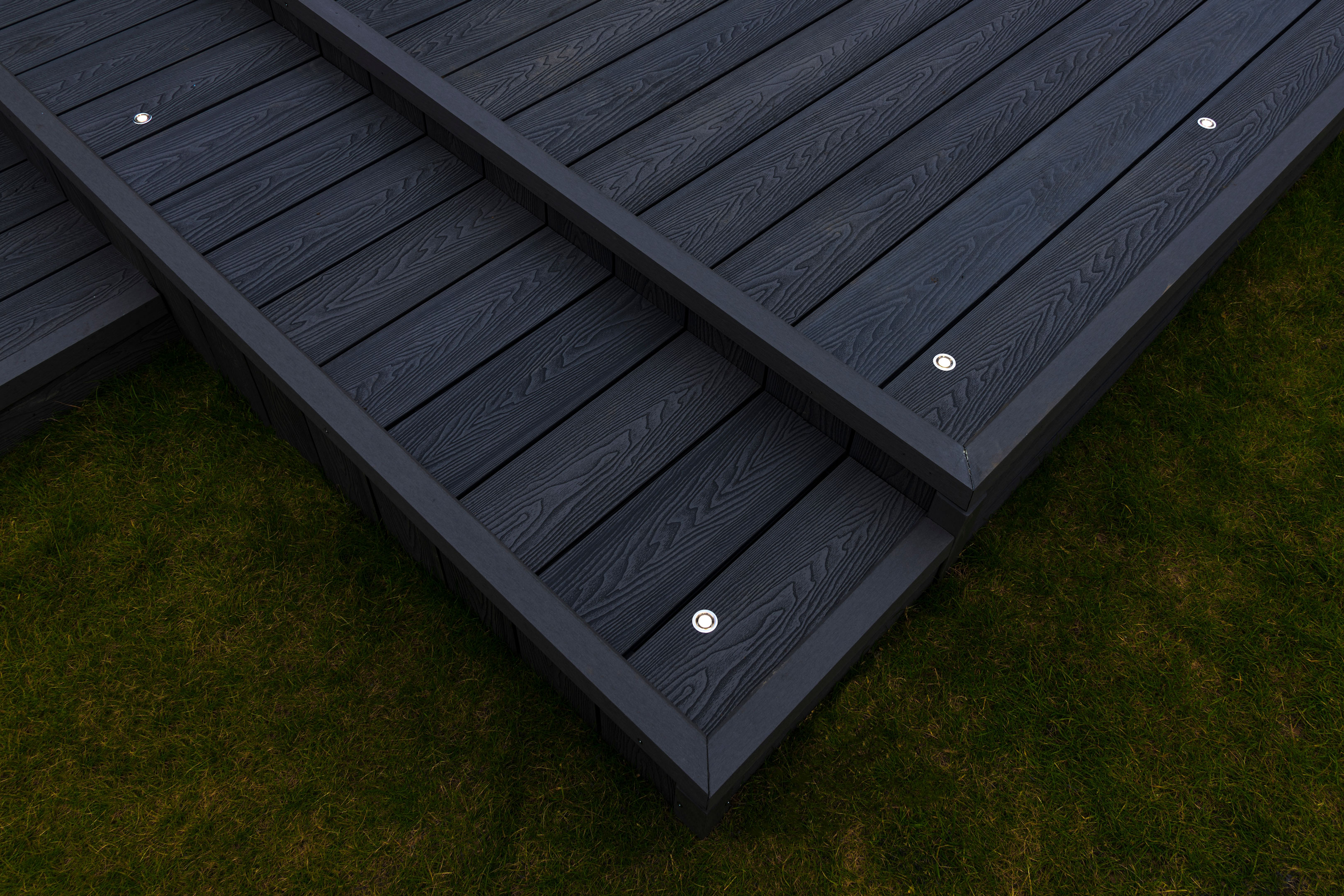 Decking Mark lights in stainless steel installed on a dark colour deck