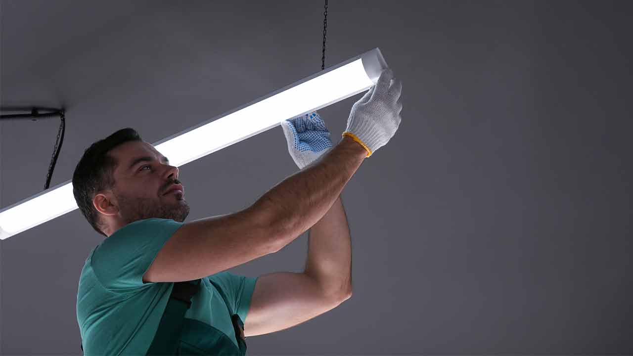 Ceiling light. Electrician installing led linear lamp indoors, Installation and Maintenance Batten Light