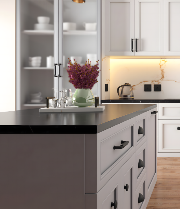 A contemporary kitchen island featuring a mix of Matt Black cup handles, knobs, and T-bar pulls on light grey cabinetry with a black stone worktop.